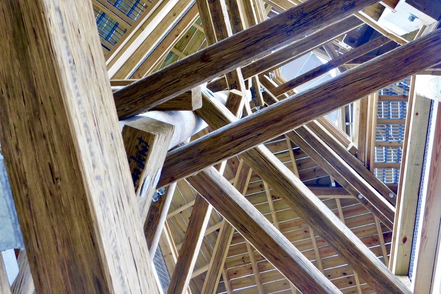 Wooden beams crisscrossing below a skylight