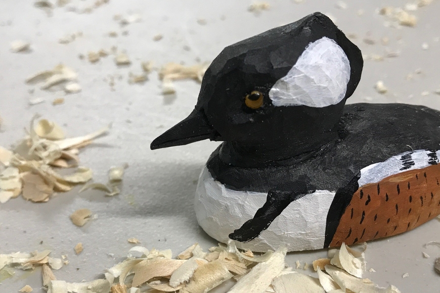 carved wooden duck with wood shavings