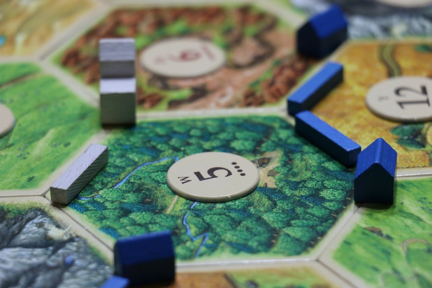 close up photo of settlers of catan game pieces on board