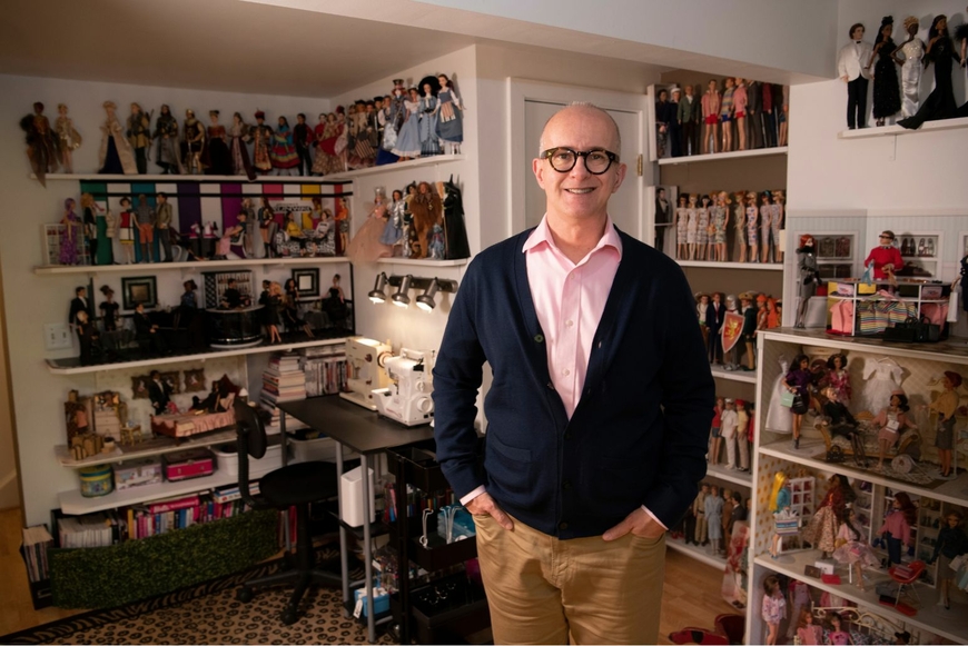 Peter Harrigan standing in front of his Barbie collection