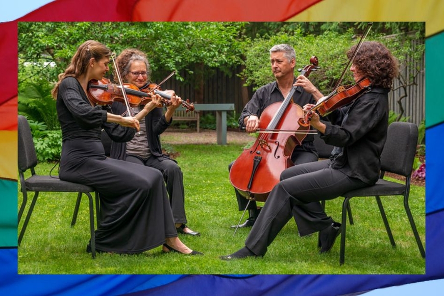 A string quartet dressed in black perform outside.