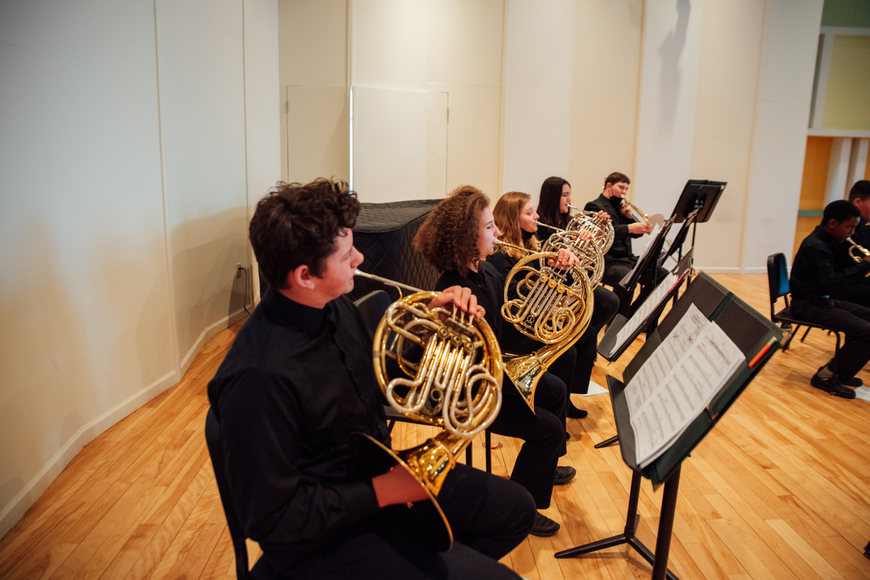 5 young musicians playing brass instruments