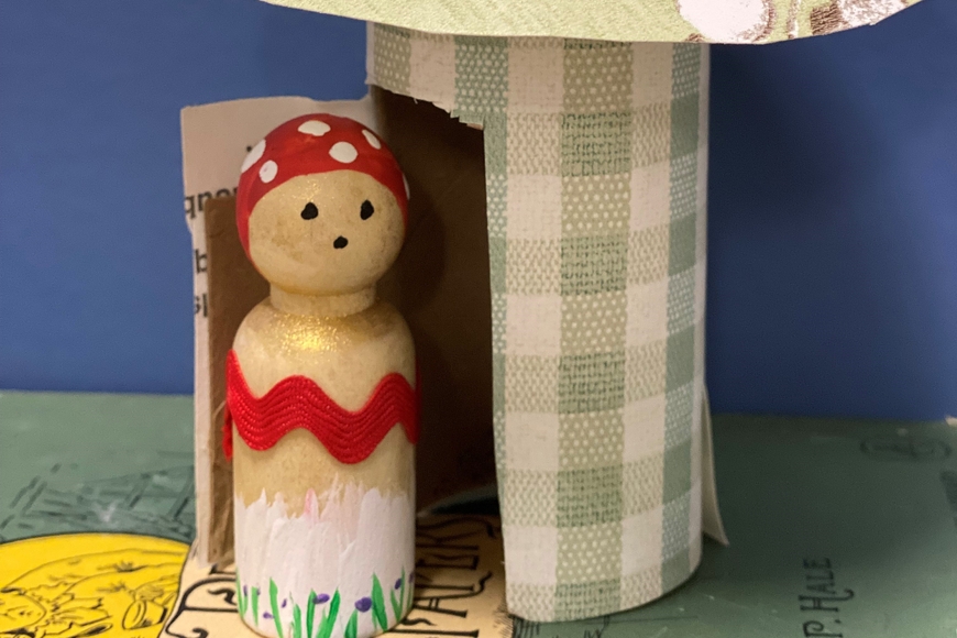 Wooden peg doll in a house